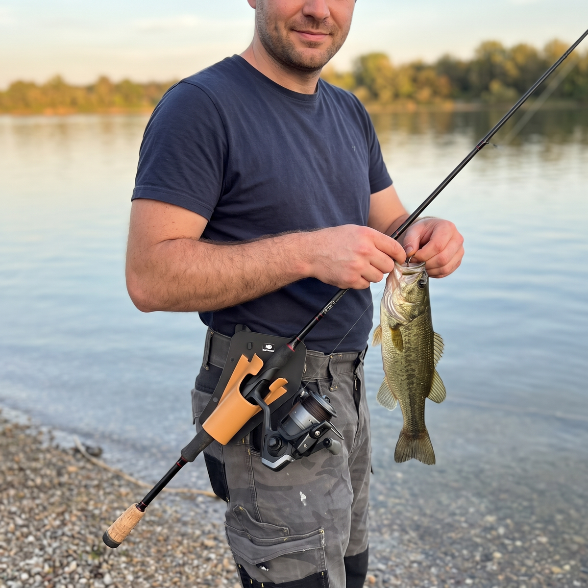 Angler unhooking a bass with both hands while the rod rests in the holster