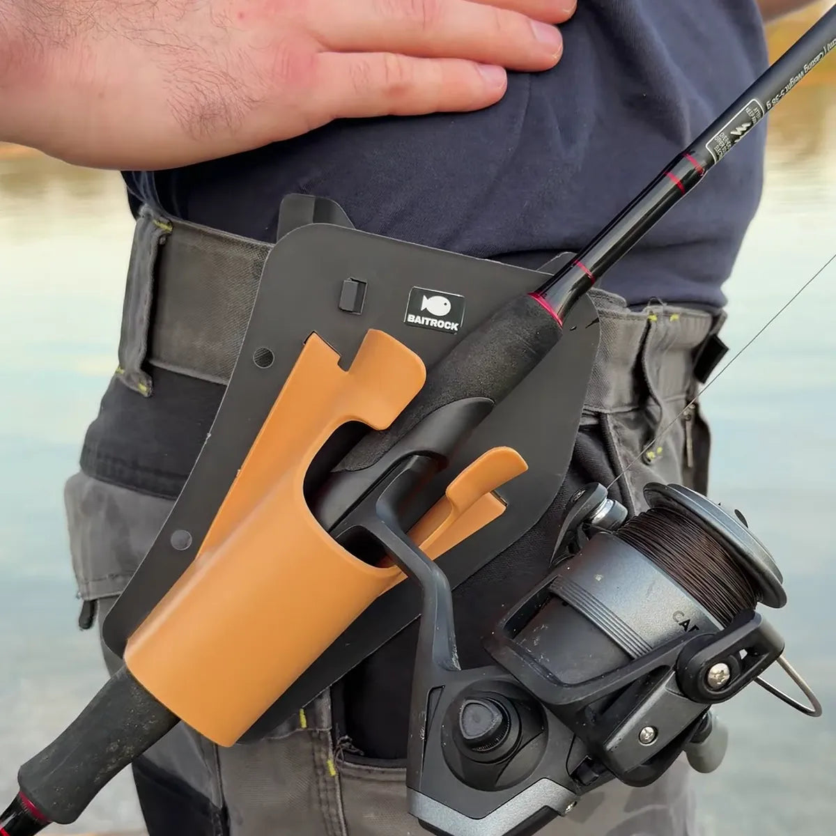 Spinning rod resting in the holster on an angler's belt